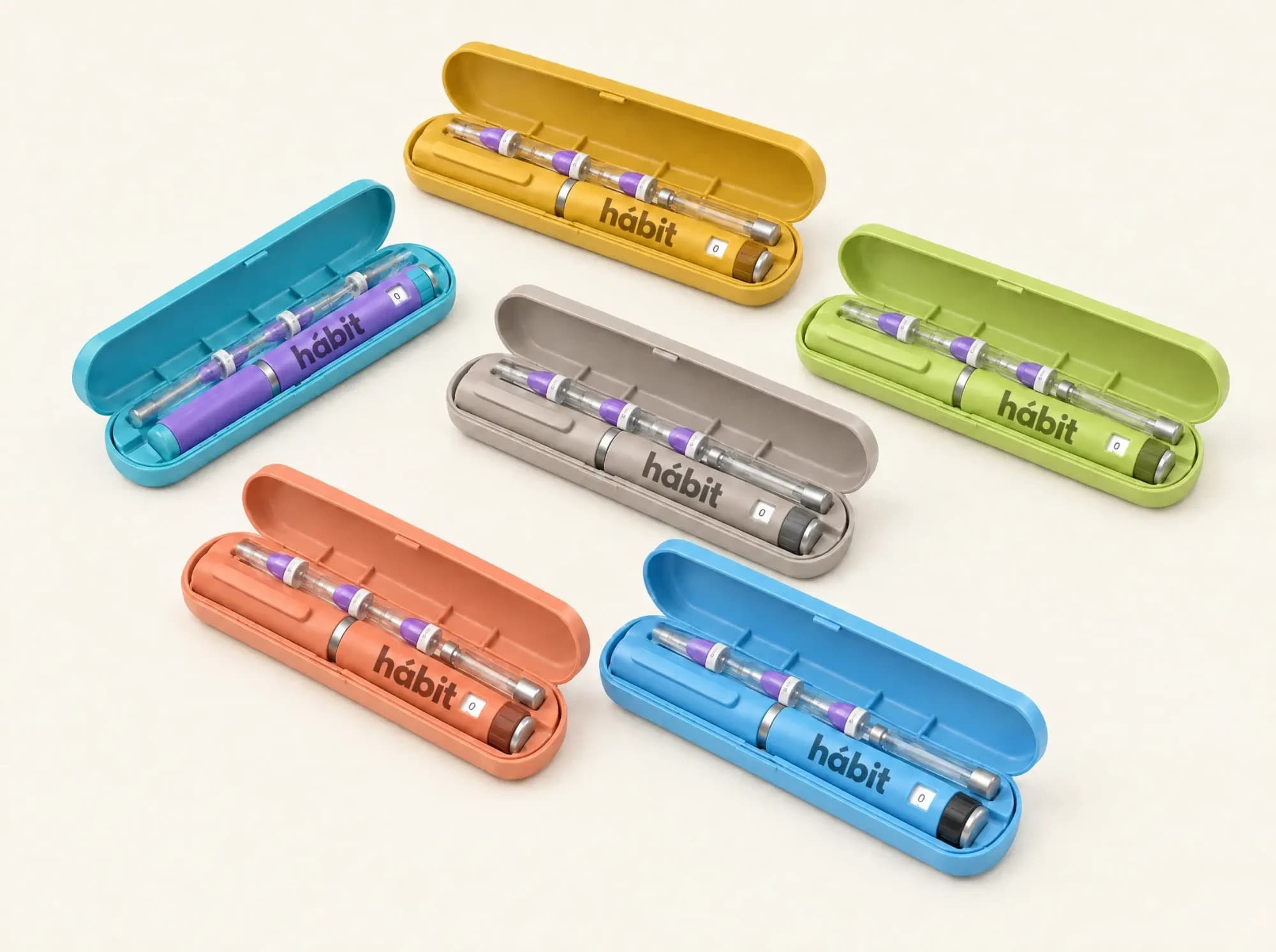 Research Kit — Bench accessory. Research Kit — twist-lock cases in six colours, each with a matching hábit pen, two of them open to show the cartridge and point slots through the side window.